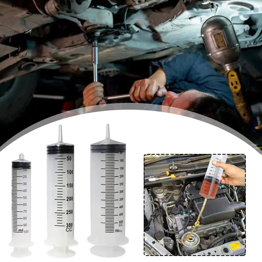 Mechanic-working-on-a-car-with-oil-draining-syringes-displayed
